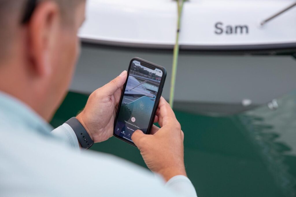 Boat owner taking photos of a boat before publishing an online rental listing.