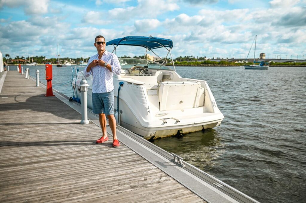 An American boat owner beside a recreational boat in a marina.