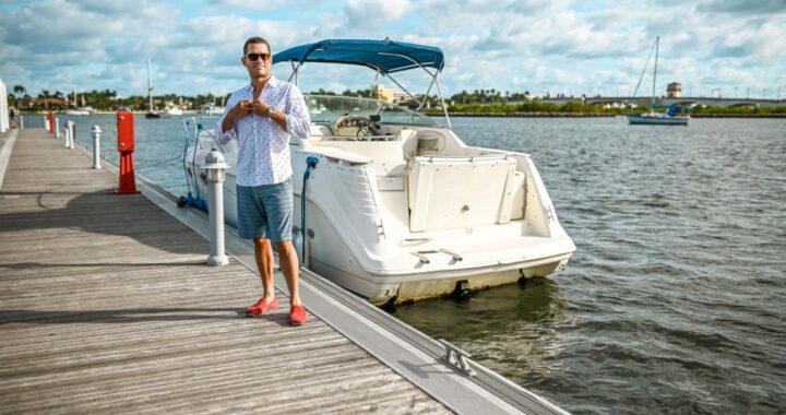 An American boat owner beside a recreational boat in a marina.