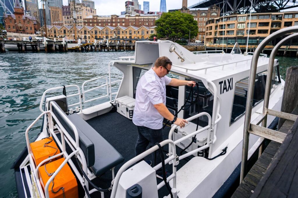 Professional water taxi captain docking a passenger boat at a modern marina.