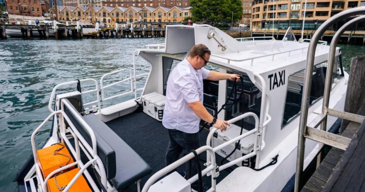 Professional water taxi captain docking a passenger boat at a modern marina.