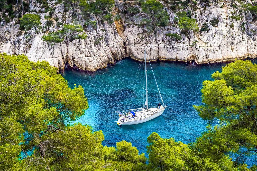 Aerial view of Calanques National Park showing white limestone cliffs and crystal-clear Mediterranean water near Cassis.