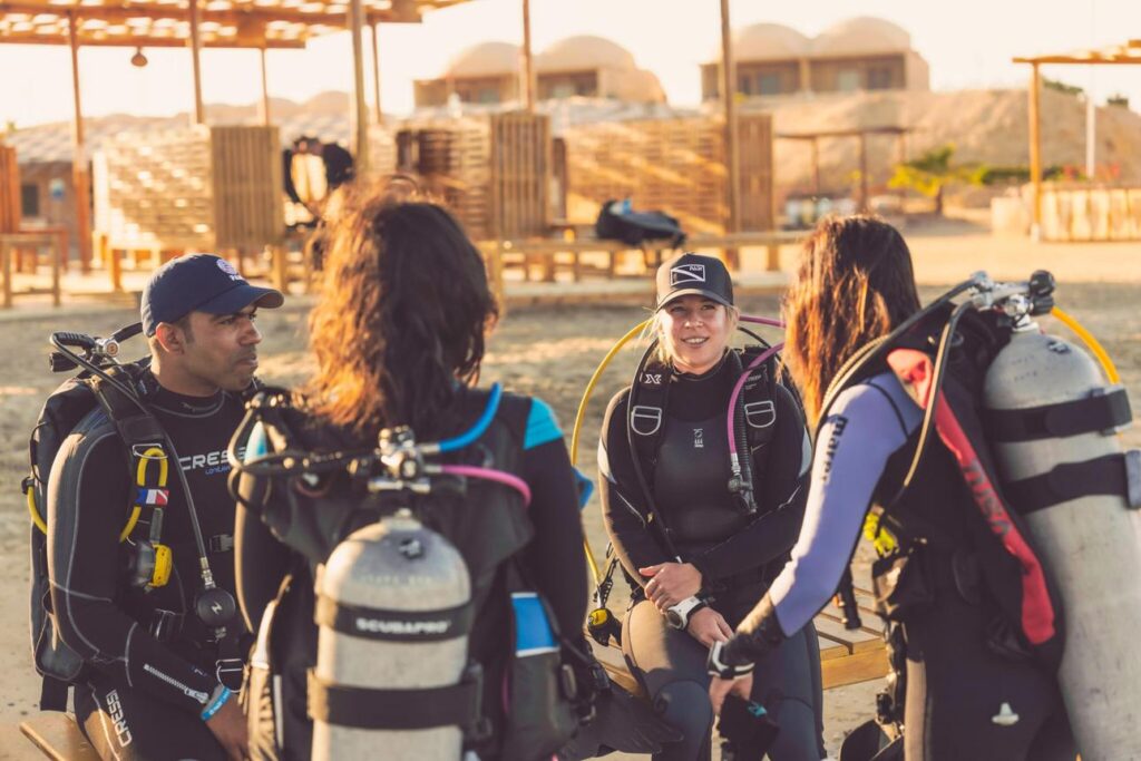 Two independent scuba diving instructors preparing students before an open water lesson.