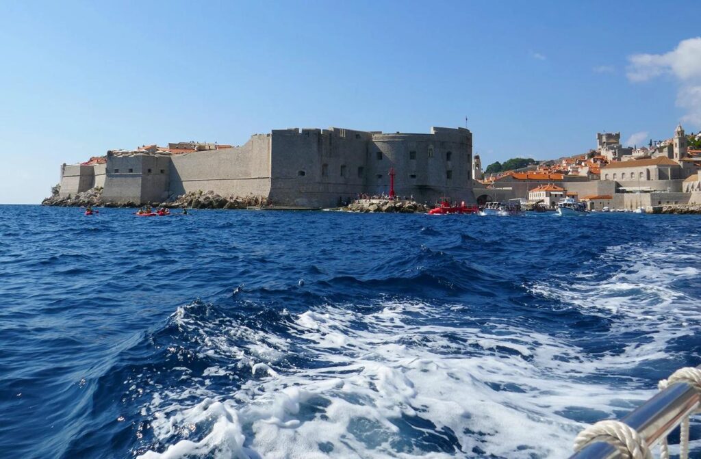 Historic Mediterranean towns viewed from a private boat during a yacht charter.