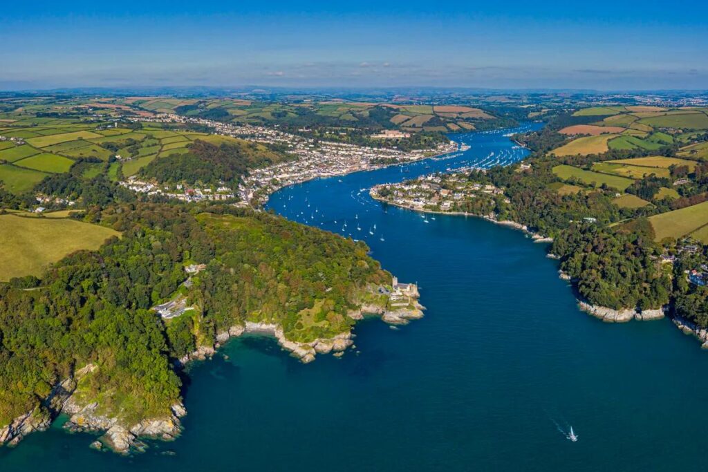 Boat cruising along the River Dart estuary between Dartmouth and Totnes in Devon.