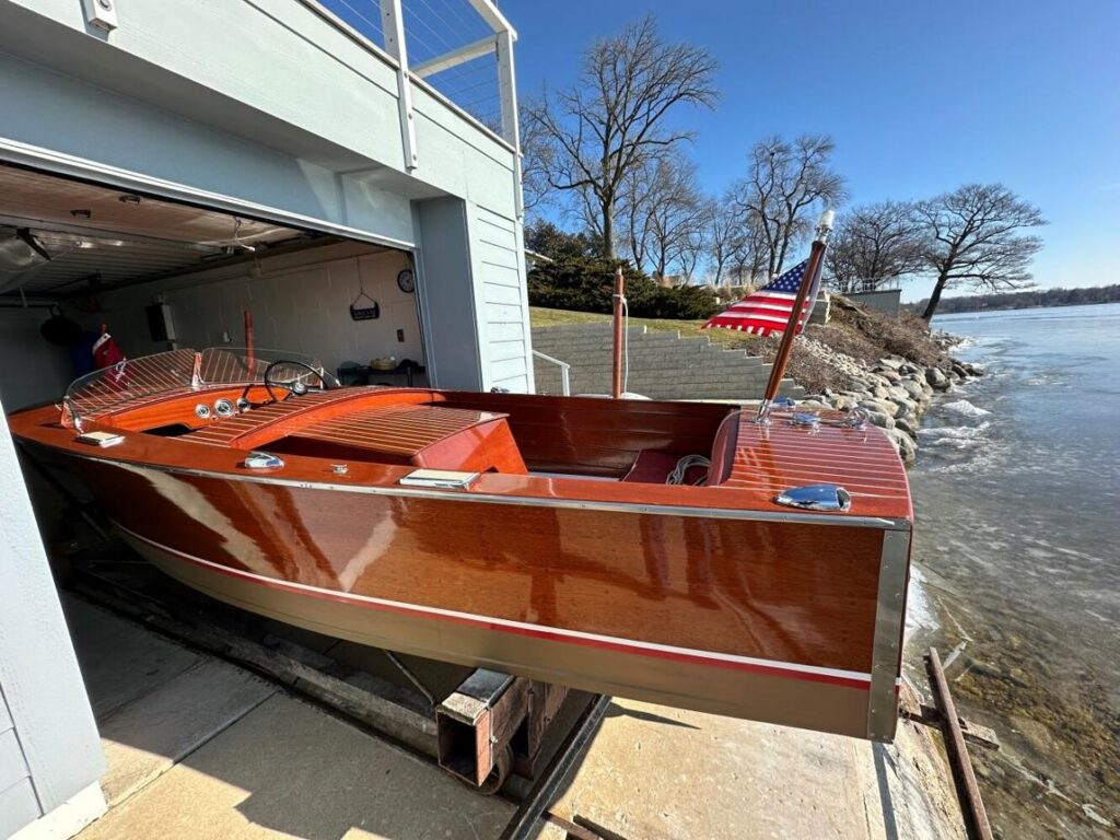 Restored 1952 Chris-Craft mahogany runabout cruising on the Chesapeake Bay, showcasing why vintage wooden boat charters have become one of America's most sought-after luxury experiences.
