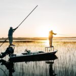 Local fishing guide navigating Louisiana marshes at sunrise during a private fishing charter.