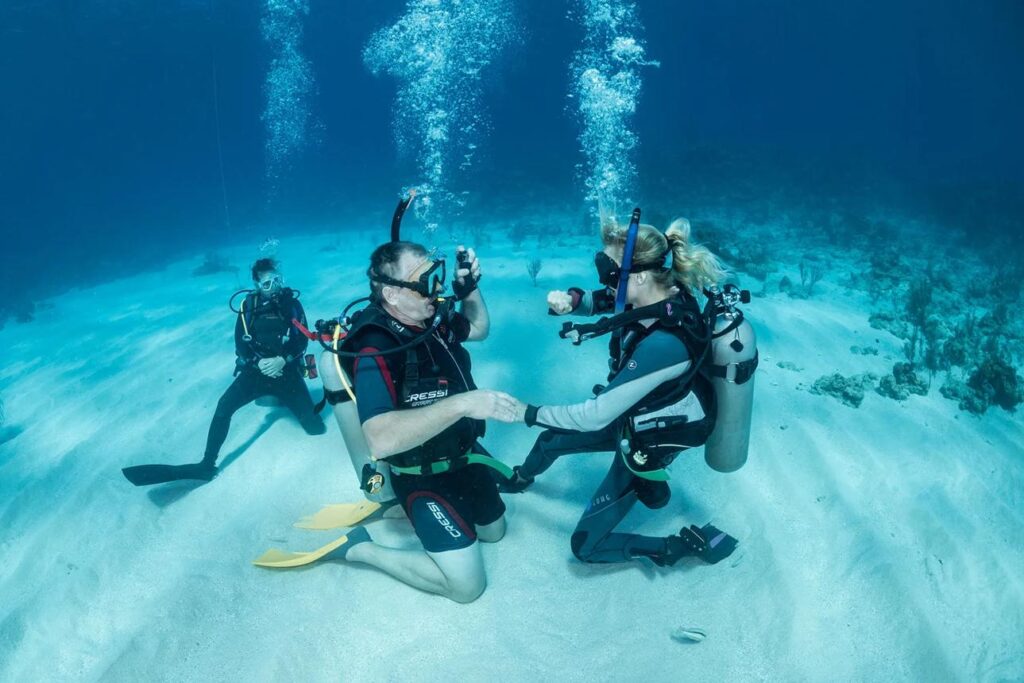 Professional PADI dive instructor teaching scuba diving students in Florida during an open water certification course.