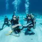 Professional PADI dive instructor teaching scuba diving students in Florida during an open water certification course.