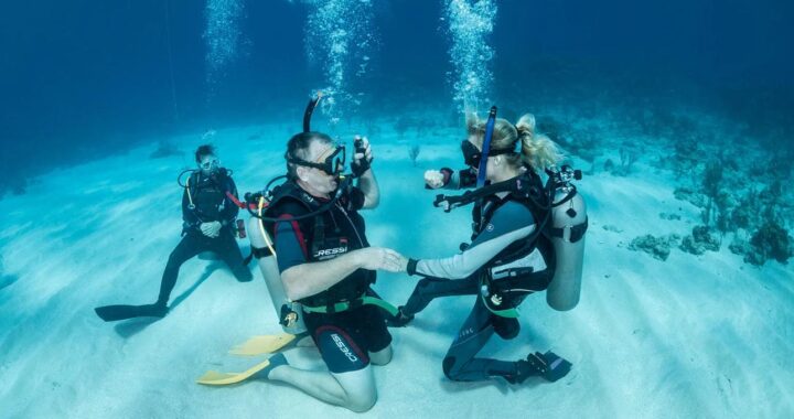 Professional PADI dive instructor teaching scuba diving students in Florida during an open water certification course.