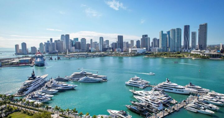 Aerial view of Biscayne Bay filled with private boats and the Miami skyline in the background.