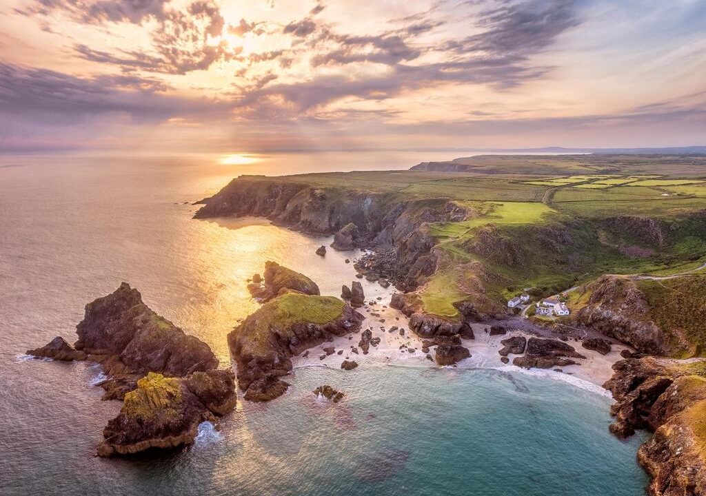 Aerial view of Cornwall's dramatic coastline and turquoise waters near Kynance Cove.