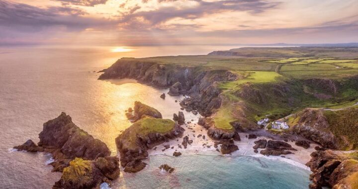 Aerial view of Cornwall's dramatic coastline and turquoise waters near Kynance Cove.