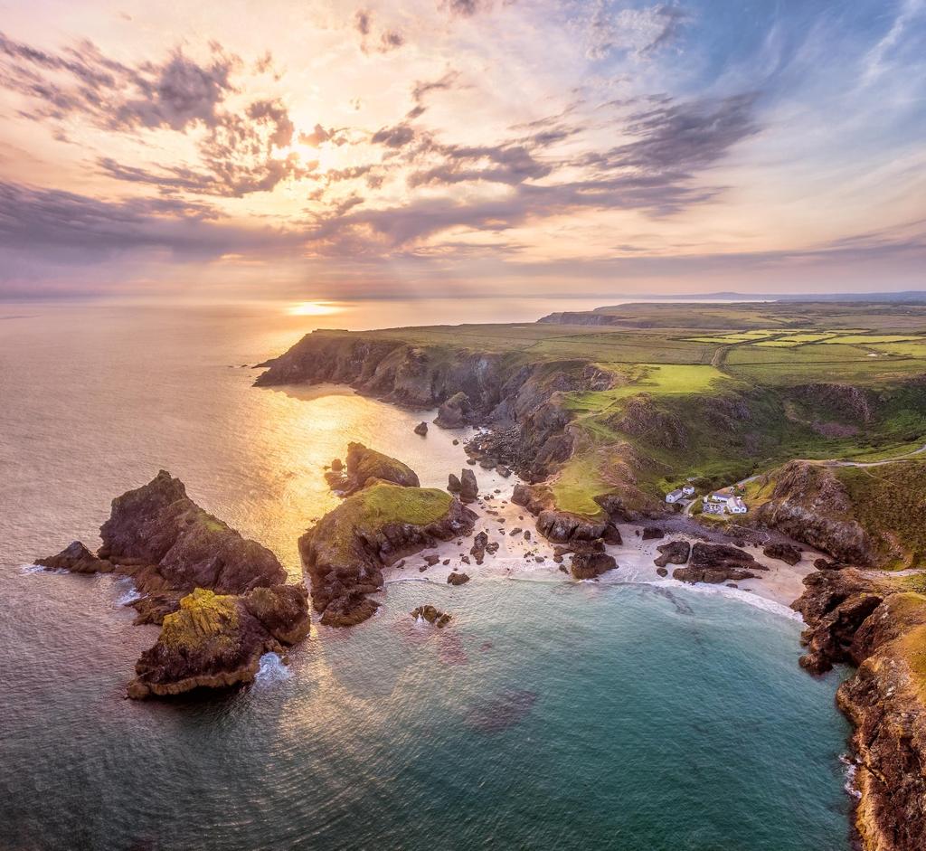 Aerial view of Cornwall's dramatic coastline and turquoise waters near Kynance Cove.