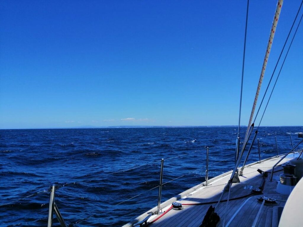 Open ocean horizon viewed from a sailboat during a wellness sailing trip.