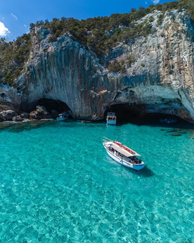 Luxury boat sailing past Positano on the Amalfi Coast during a summer afternoon.
